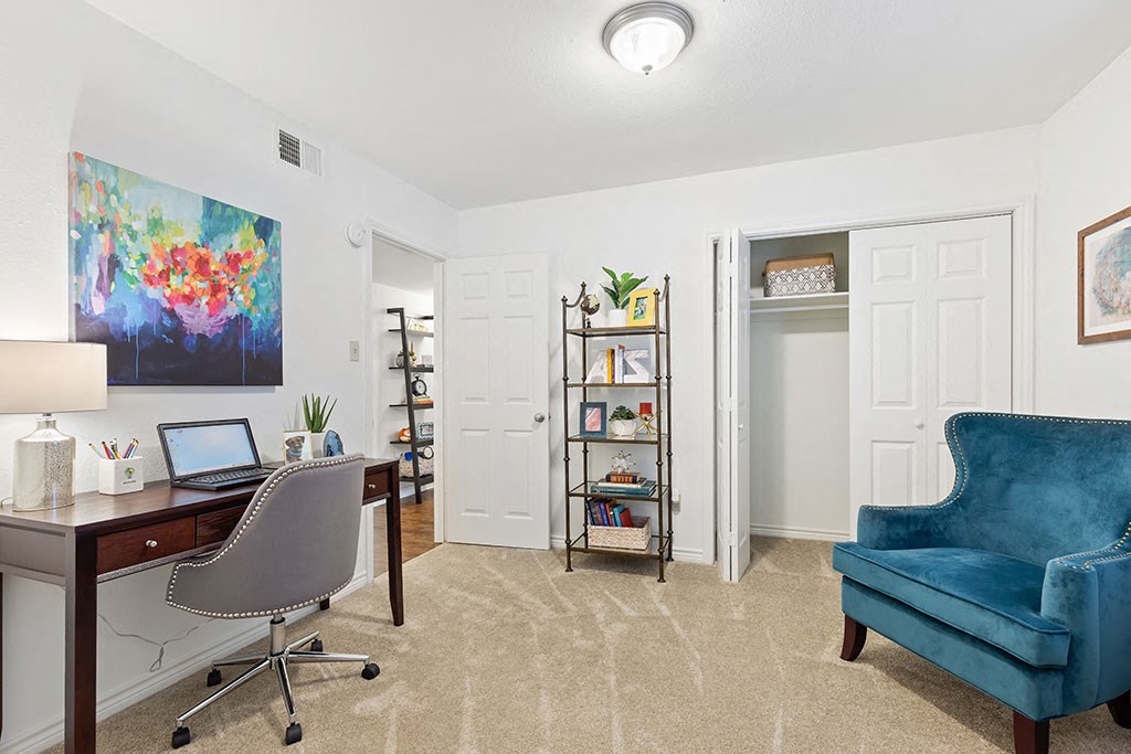 a living room with a desk and a chair