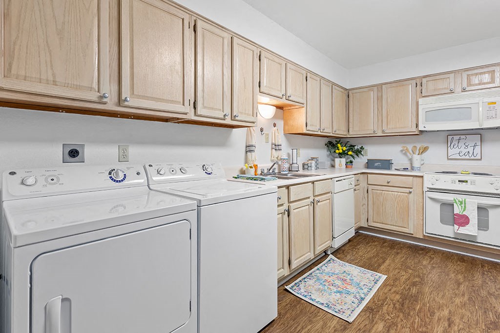 a kitchen with white appliances and wooden cabinets
