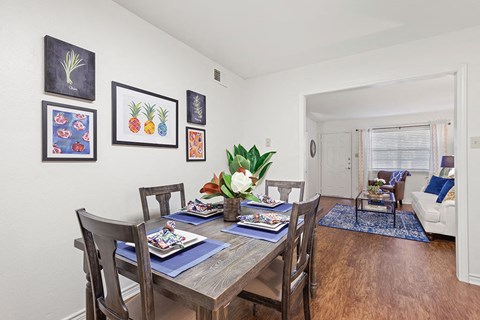 A dining room with a table set for a meal.