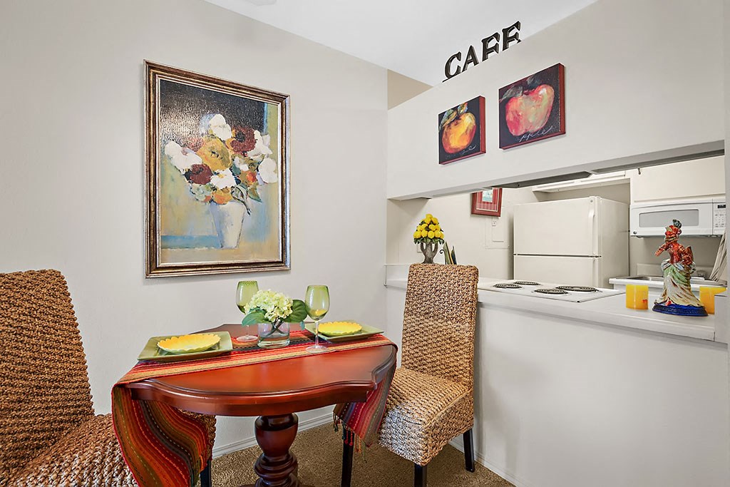 a living room with a table and a kitchen