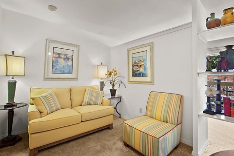 a living room with a yellow couch and a chair