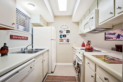 A kitchen with white cabinets and a sink.