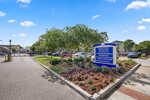 the sign at the entrance of a parking lot with a flower garden
