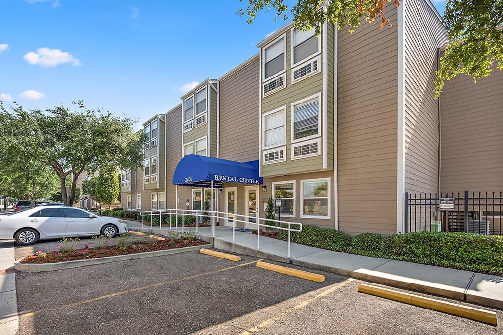 a parking lot in front of a building with a car