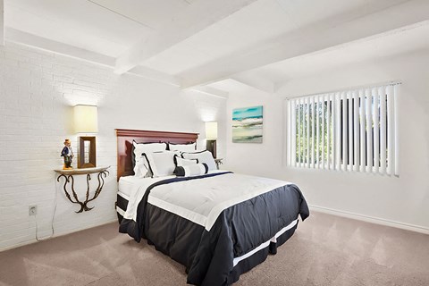 A bedroom with a large bed and a painting on the wall.