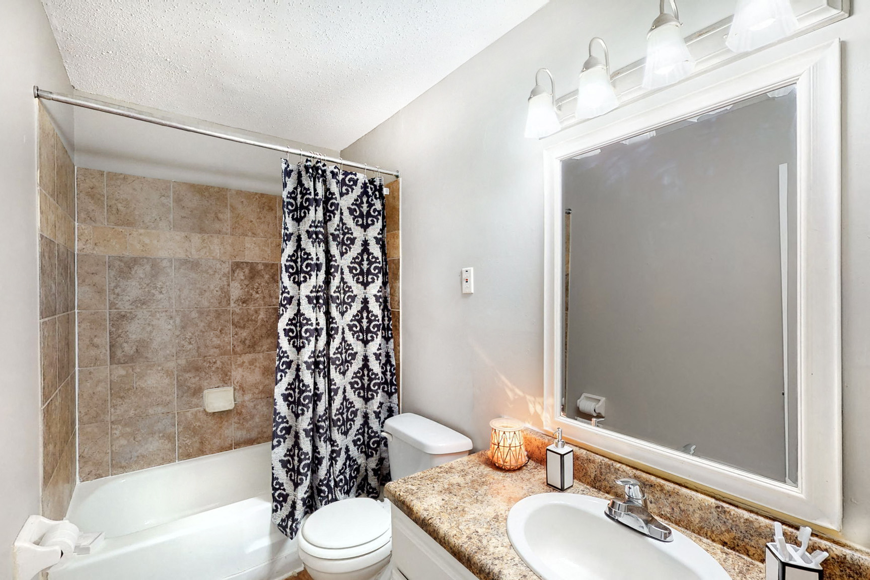 a bathroom with a shower toilet and sink and a mirror