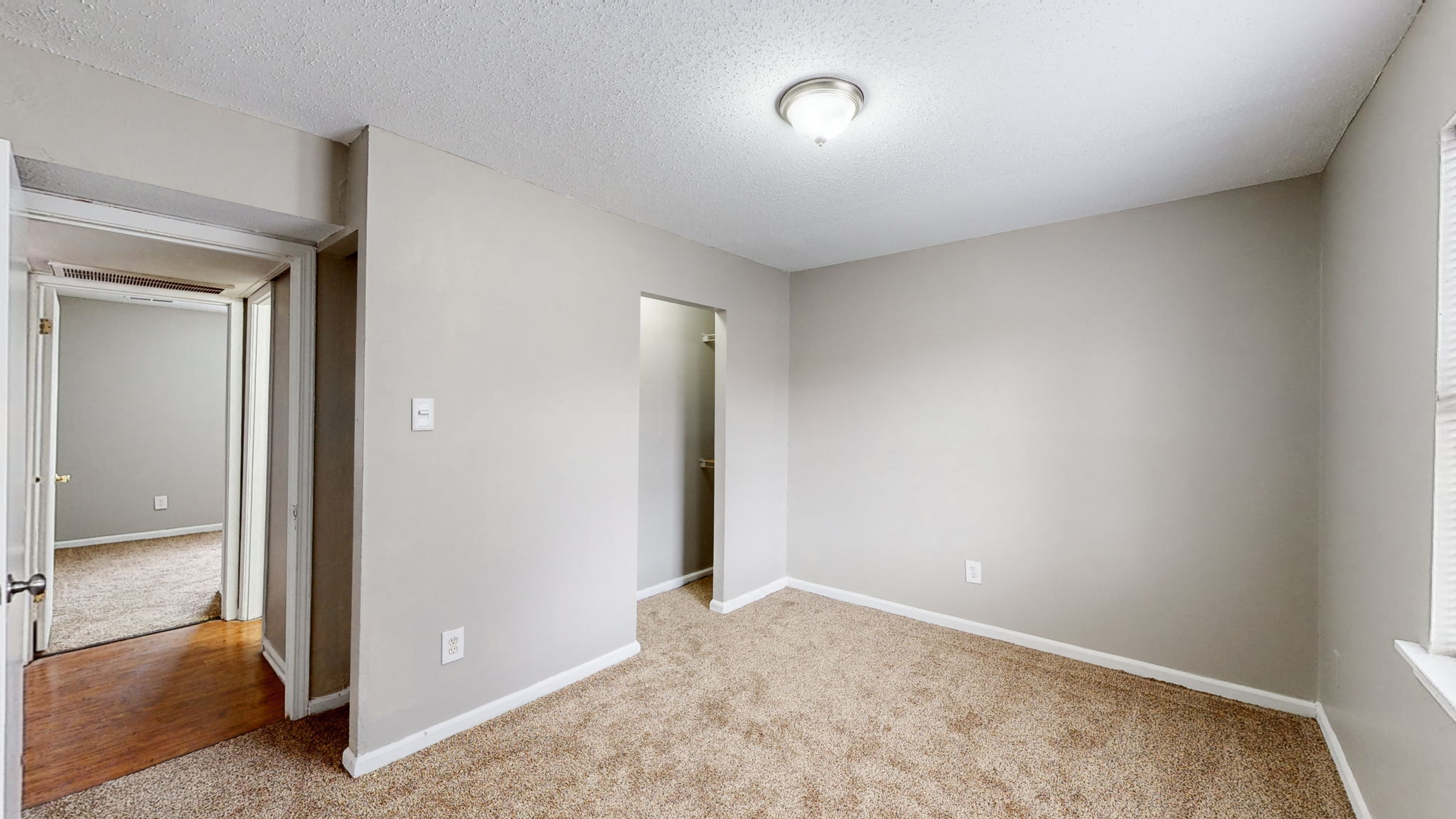 an empty living room with a door to a hallway