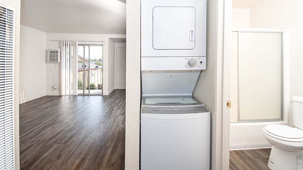 Apartments Livermore - Alderwood Park Apartments Washer & Dryer with View of Hardwood Style Flooring & Bathroom