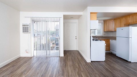 A kitchen with white appliances and wooden floors.