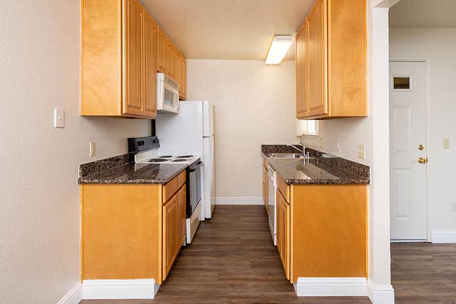 A kitchen with wooden cabinets and a granite countertop.