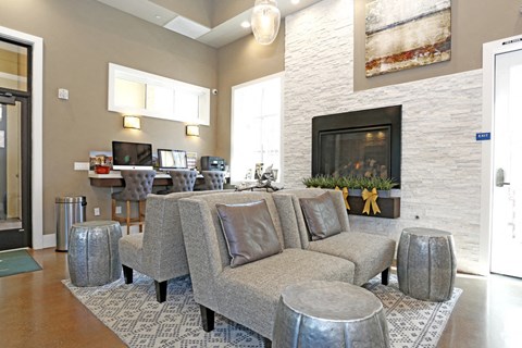 A living room with a grey couch and a fireplace.