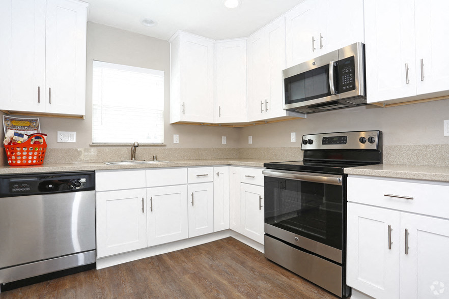 A kitchen with white cabinets and a black oven.
