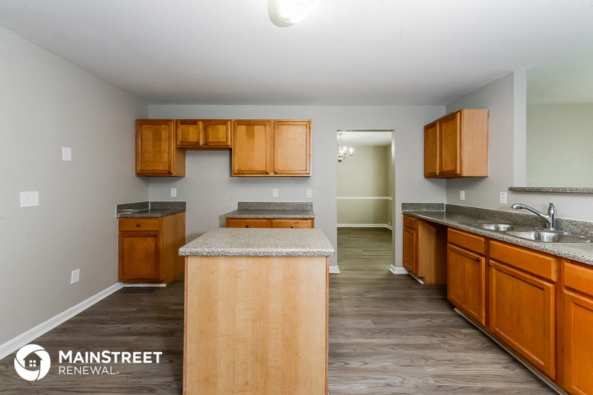 a kitchen with wooden cabinets and granite counter tops and a sink