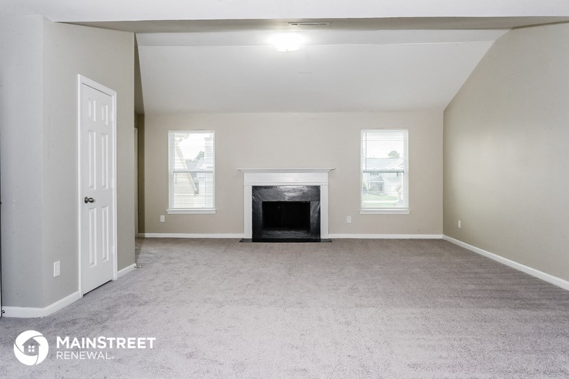 the living room of an empty house with a fireplace