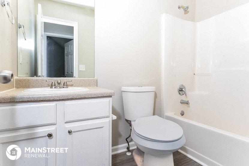 a bathroom with a toilet sink and tub and a mirror
