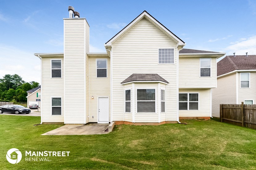 a white house with white siding and a lawn