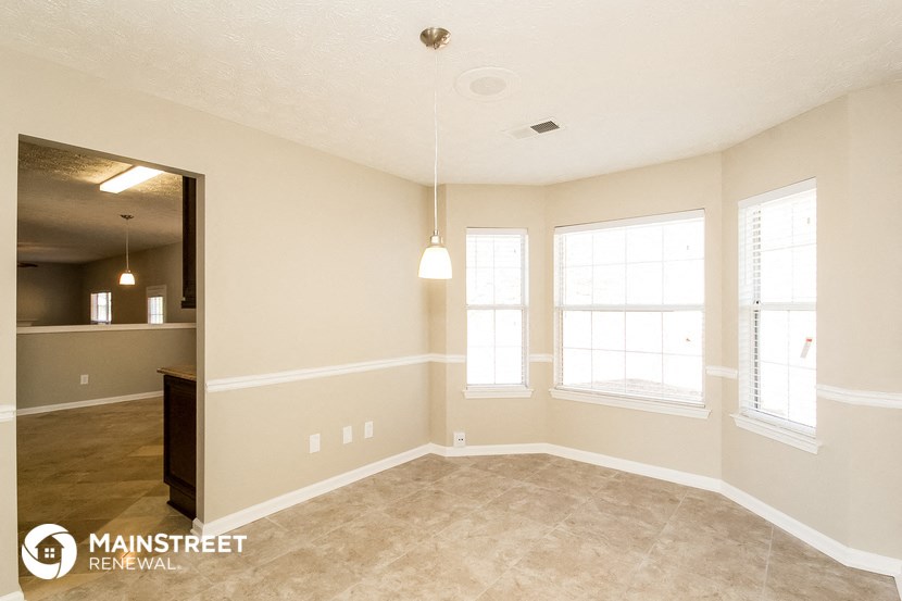 the living room and dining room of an empty house with windows