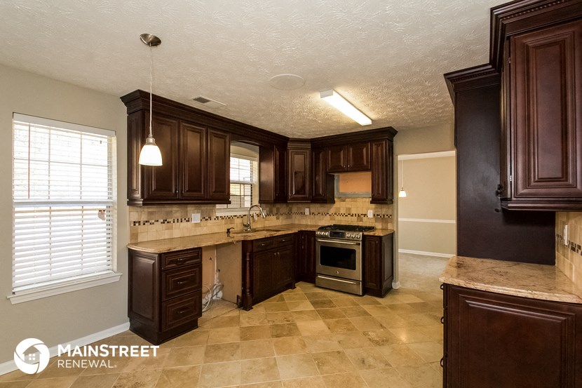a kitchen with dark wood cabinets and a large window
