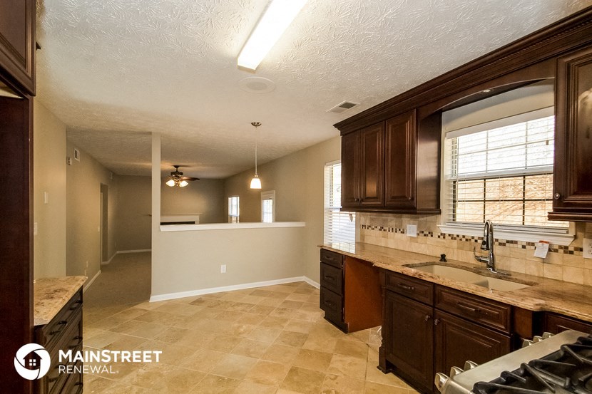 a kitchen with brown cabinets and a sink and a window