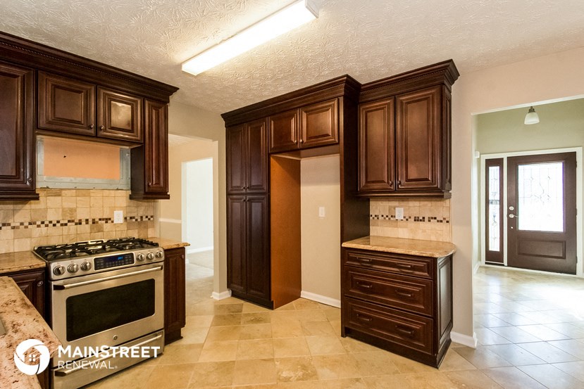a kitchen with brown cabinets and a stove and a refrigerator