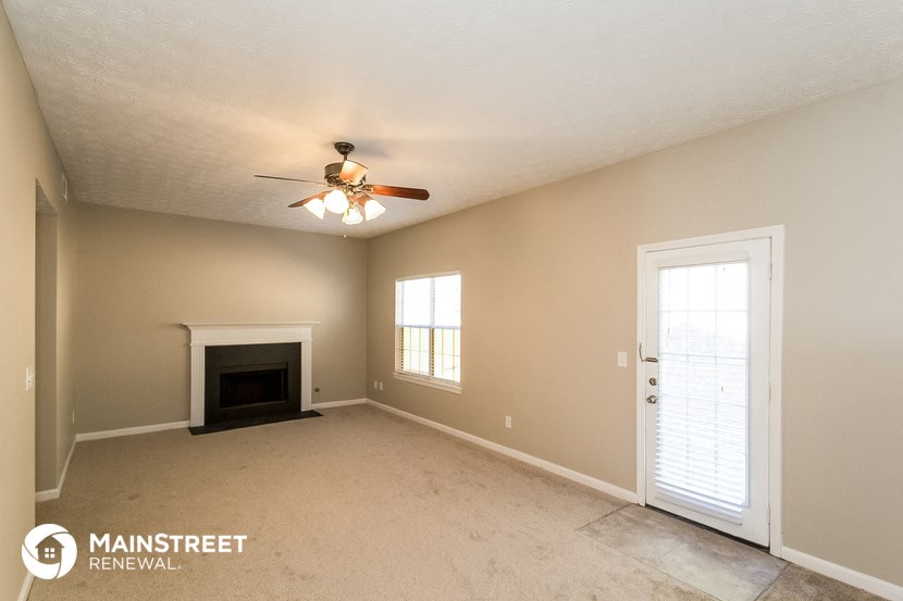 the living room with fireplace and ceiling fan