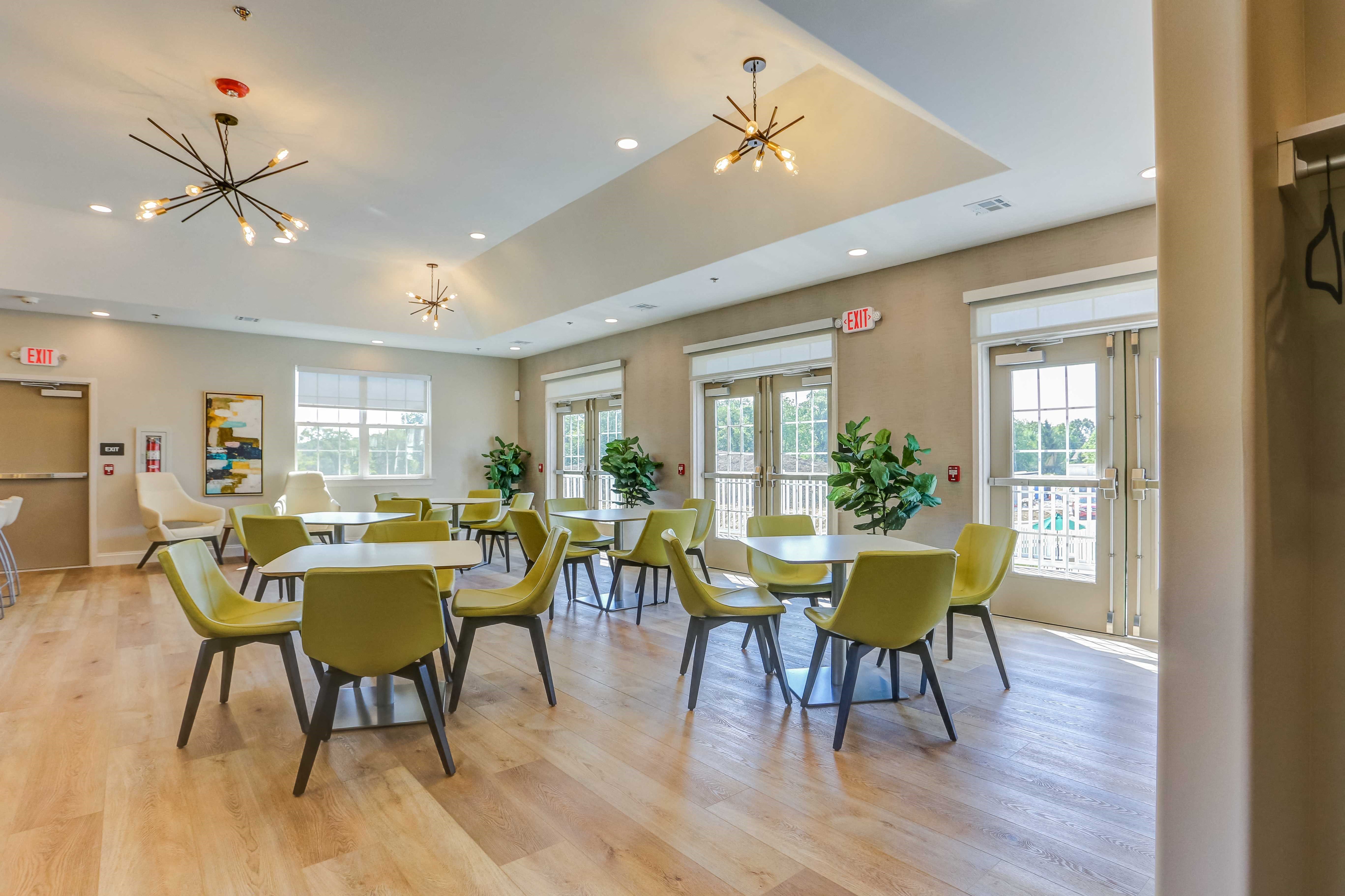 a large dining room with tables and chairs and windows