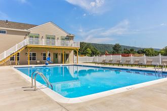 a swimming pool with a house in the background
