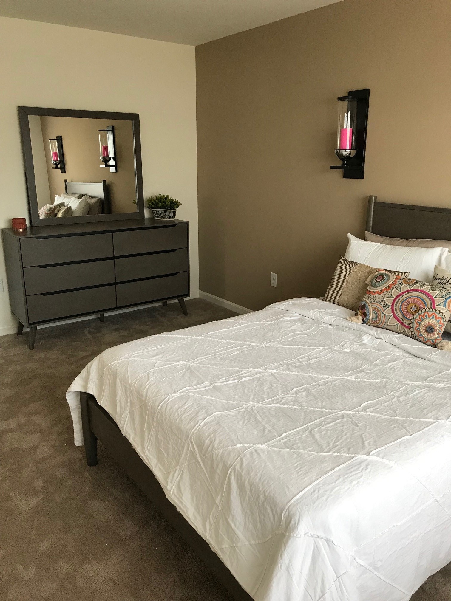 a bedroom with a bed and a dresser and a mirror