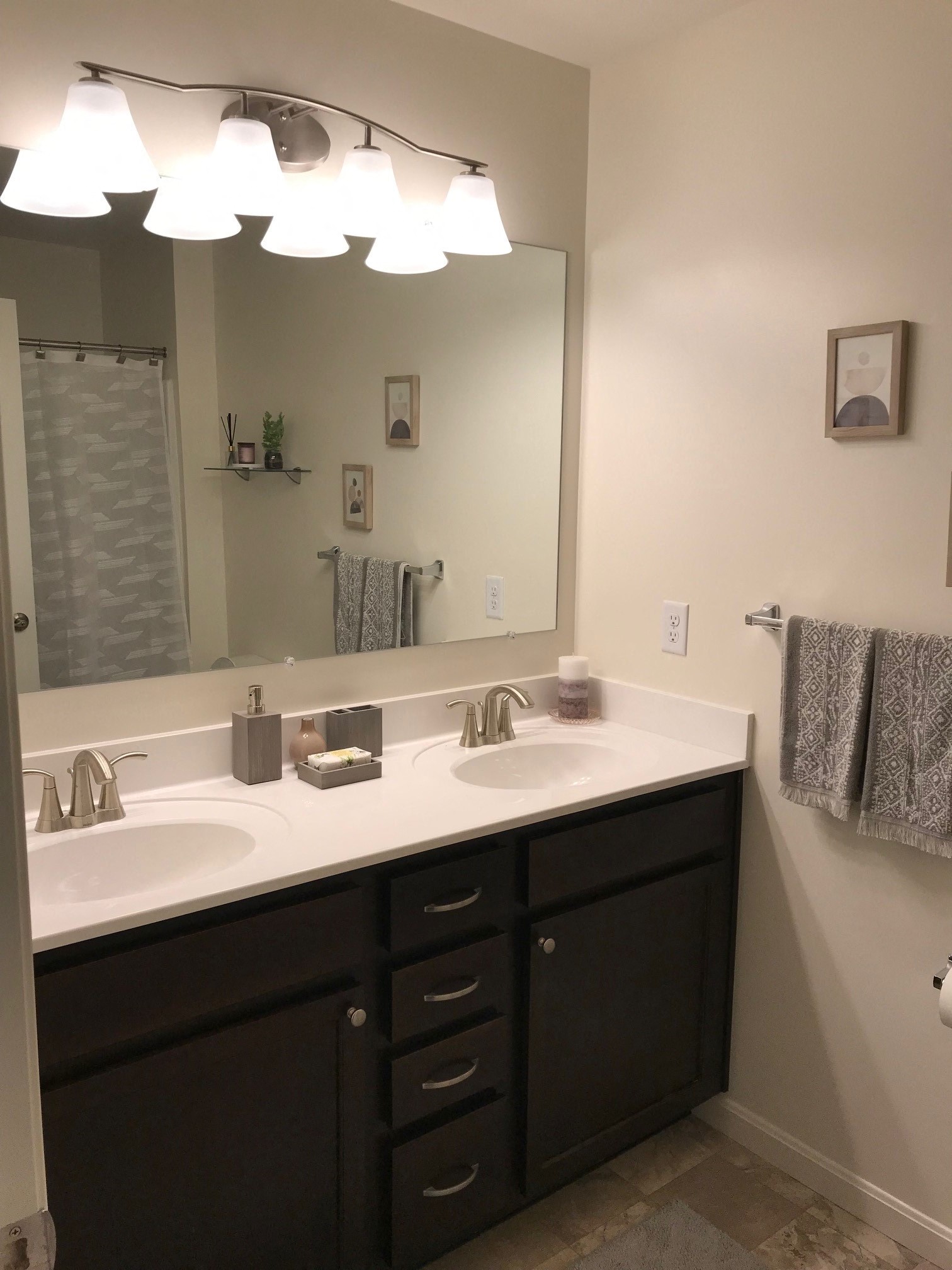 the master bathroom has two sinks and a large mirror