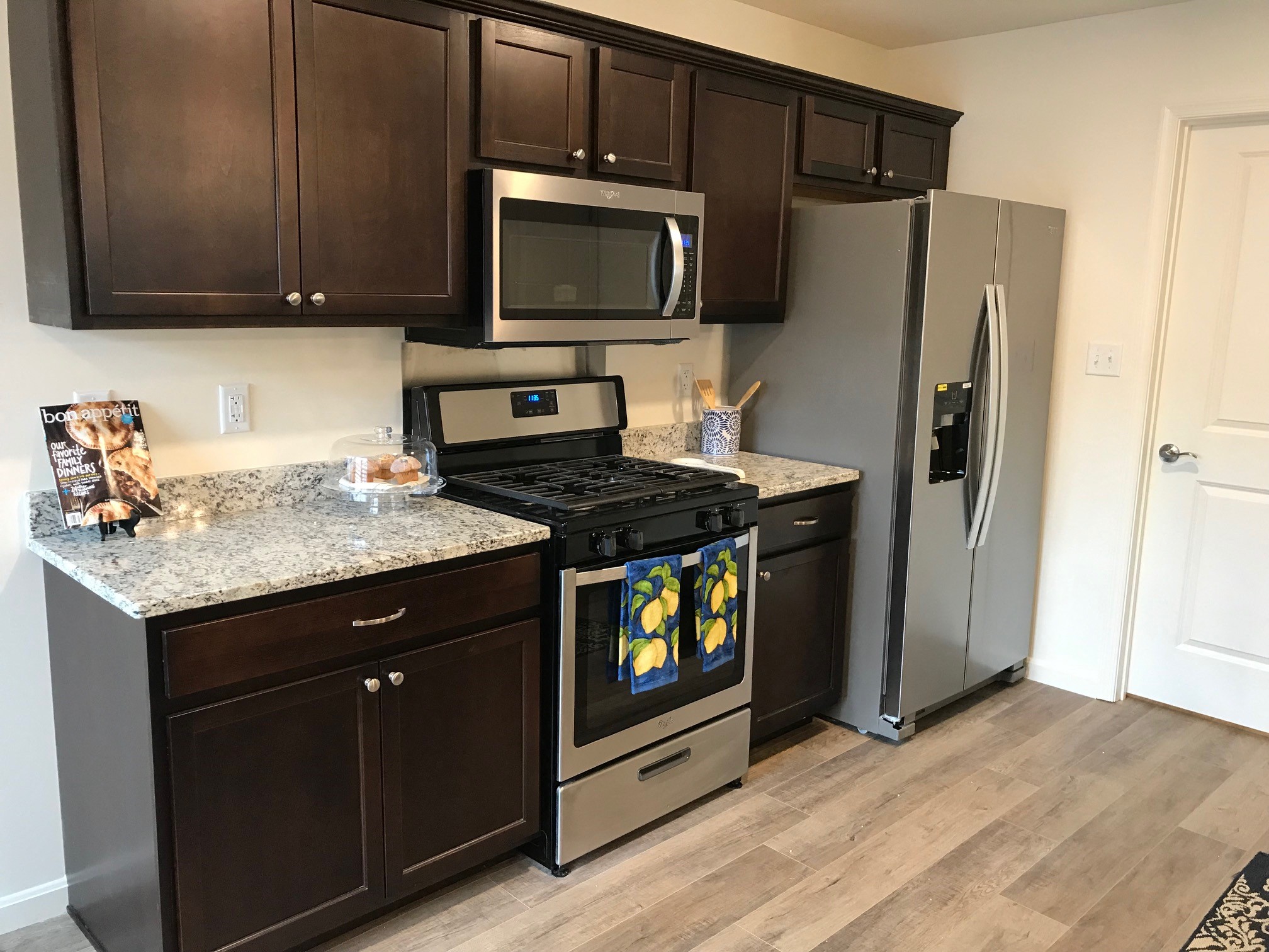an updated kitchen with stainless steel appliances and granite counter tops