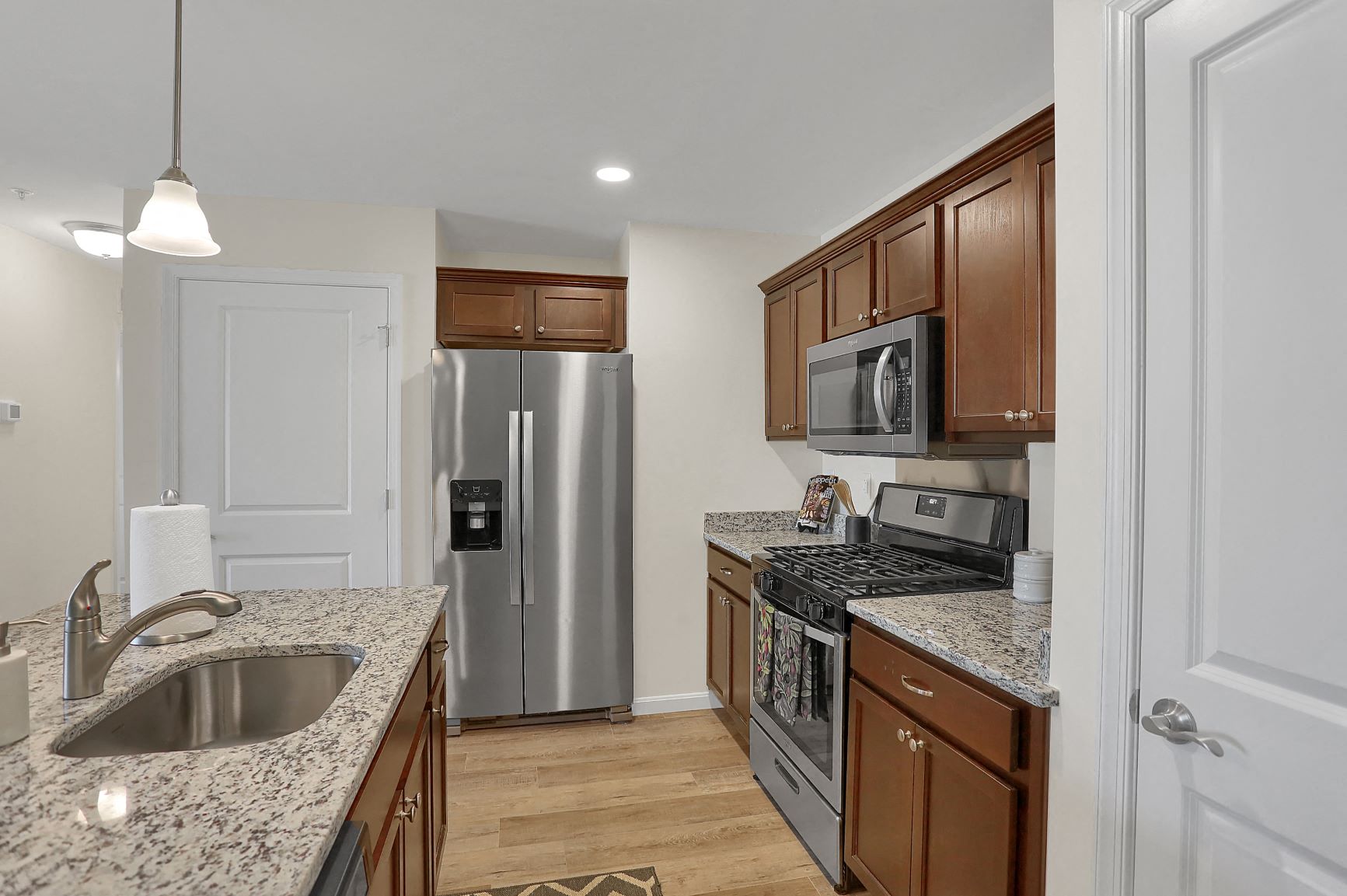 a kitchen with granite counter tops and a stainless steel refrigerator