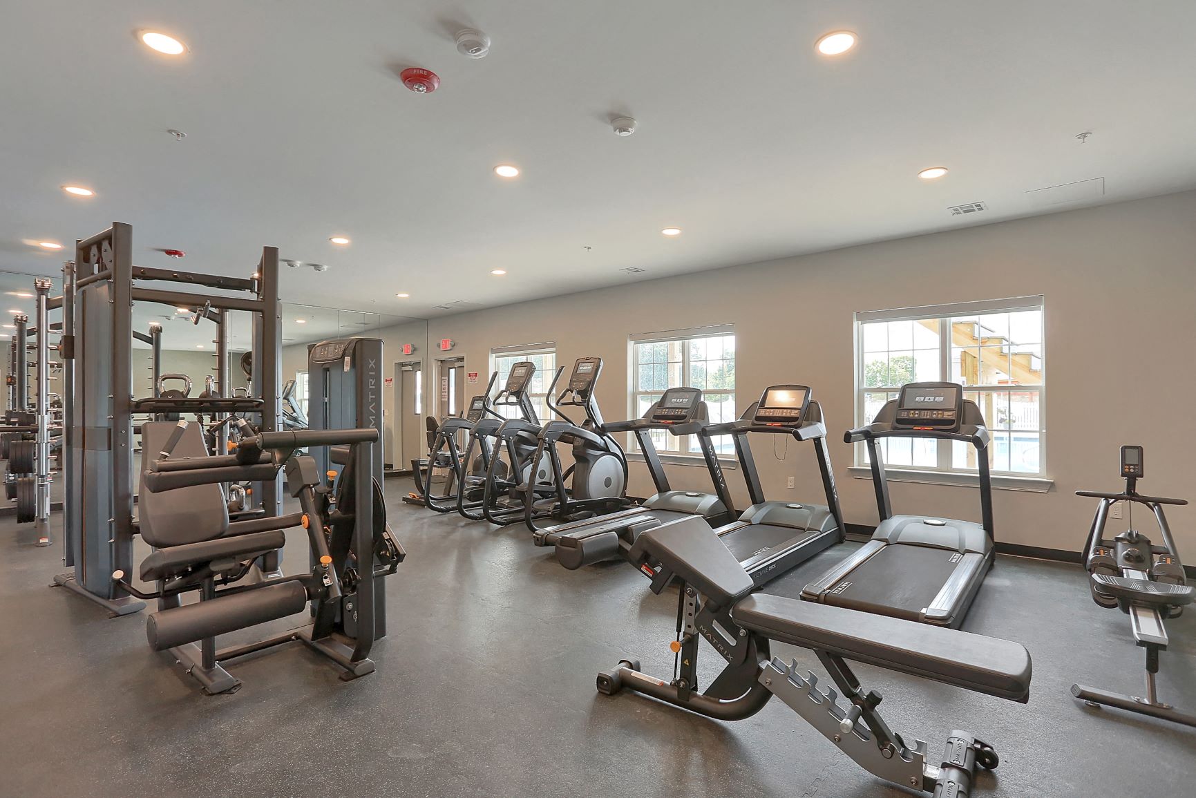 a gym with cardio equipment and weights in a building