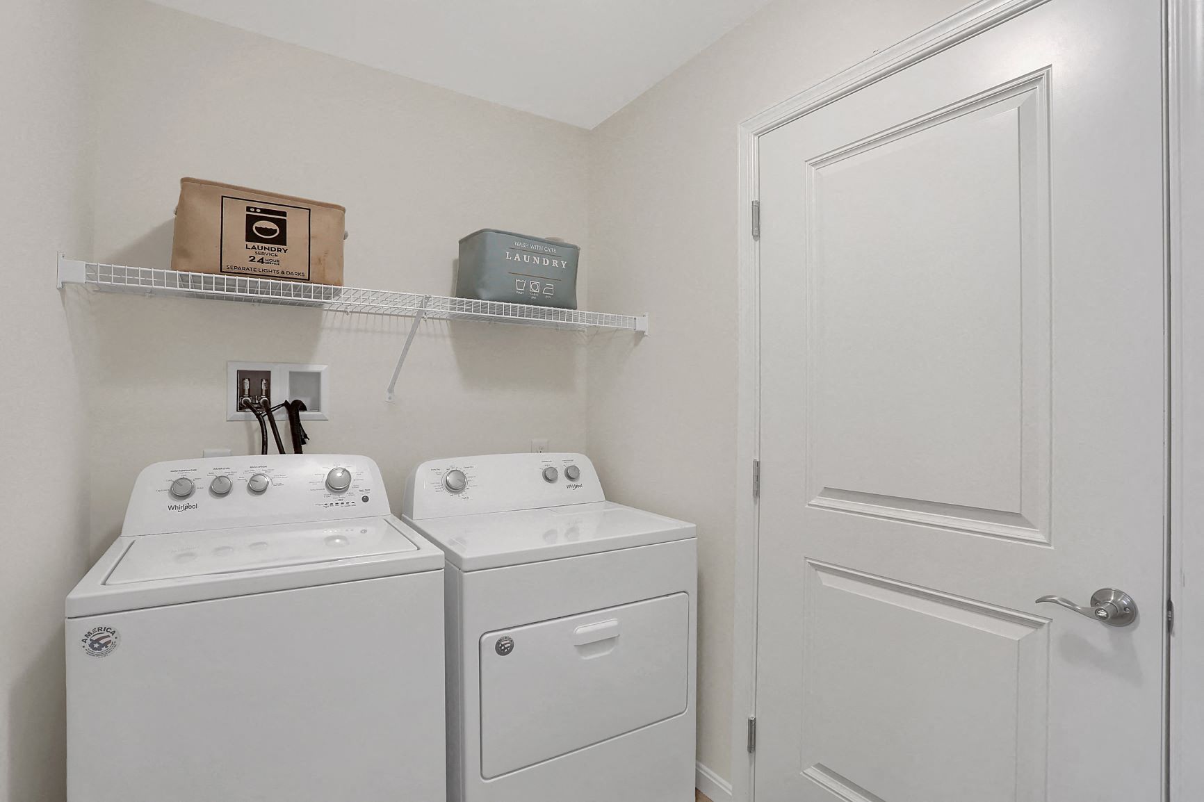 a white washer and dryer in a laundry room with a white door