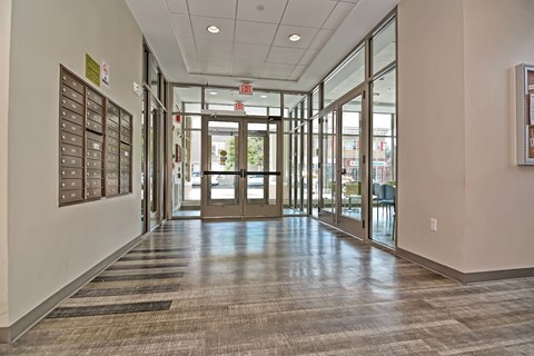 a hallway in a building with glass doors and bulletin boards