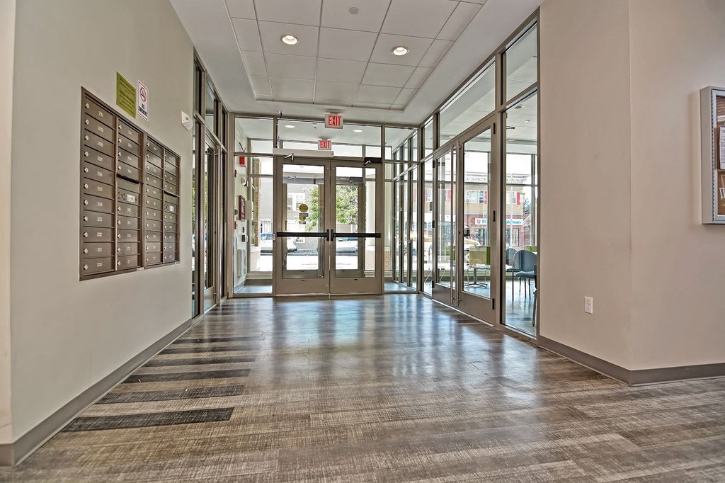 a hallway in a building with glass doors and bulletin boards