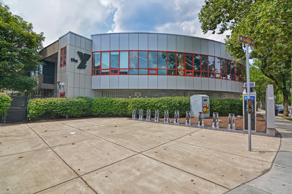 the front of a building with a sidewalk and parking meters