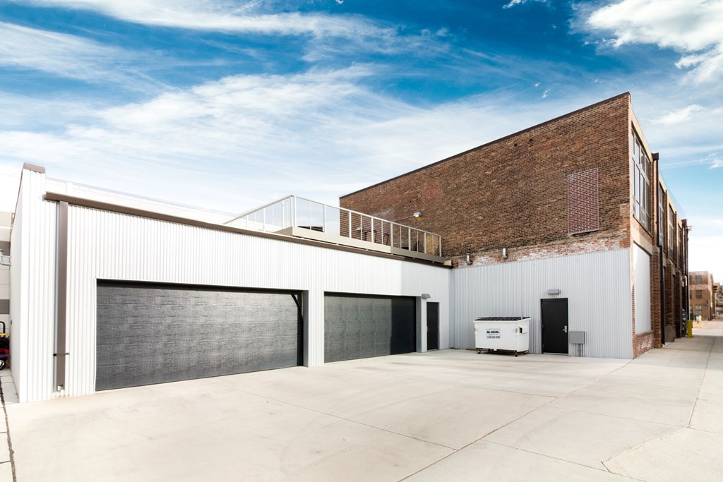 the side of a building with a garage door and a balcony