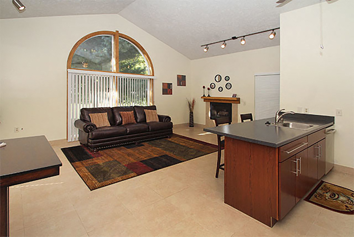 a living room with a couch and a kitchen with a sink