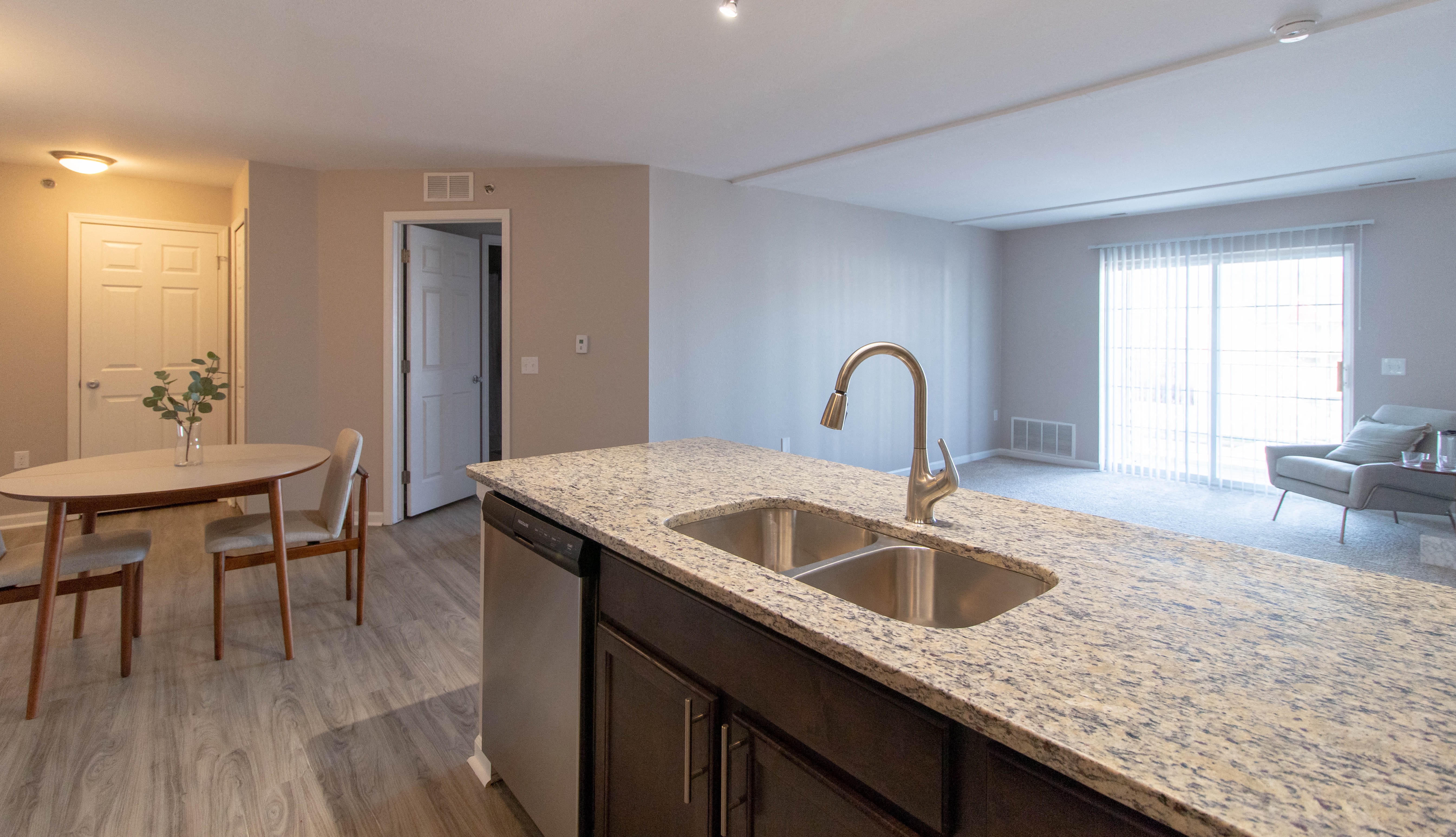 A kitchen with a sink and a dining table.