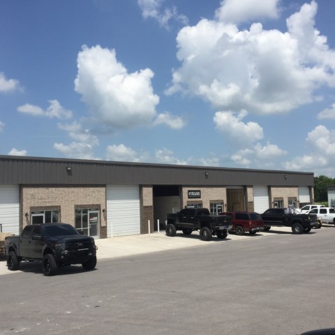A row of trucks are parked in front of a building.