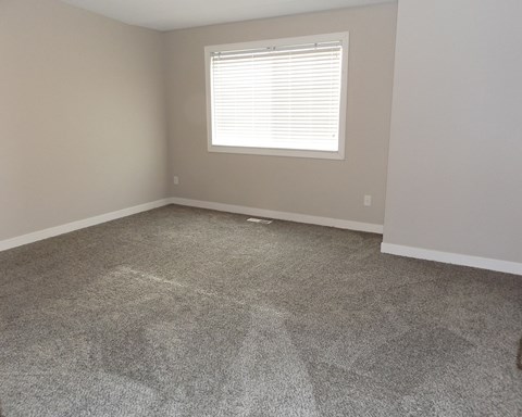 an empty room with carpet and a window