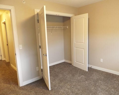 a bedroom with a closet and a door open to a closet