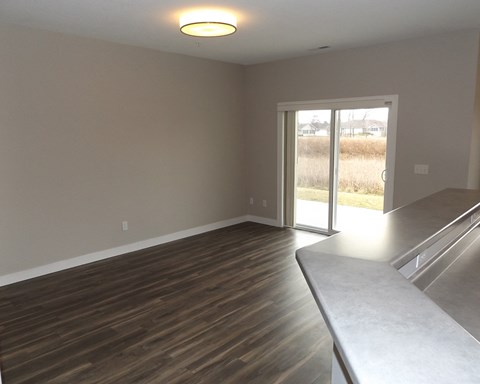 an empty living room with wood floors and a sliding glass door