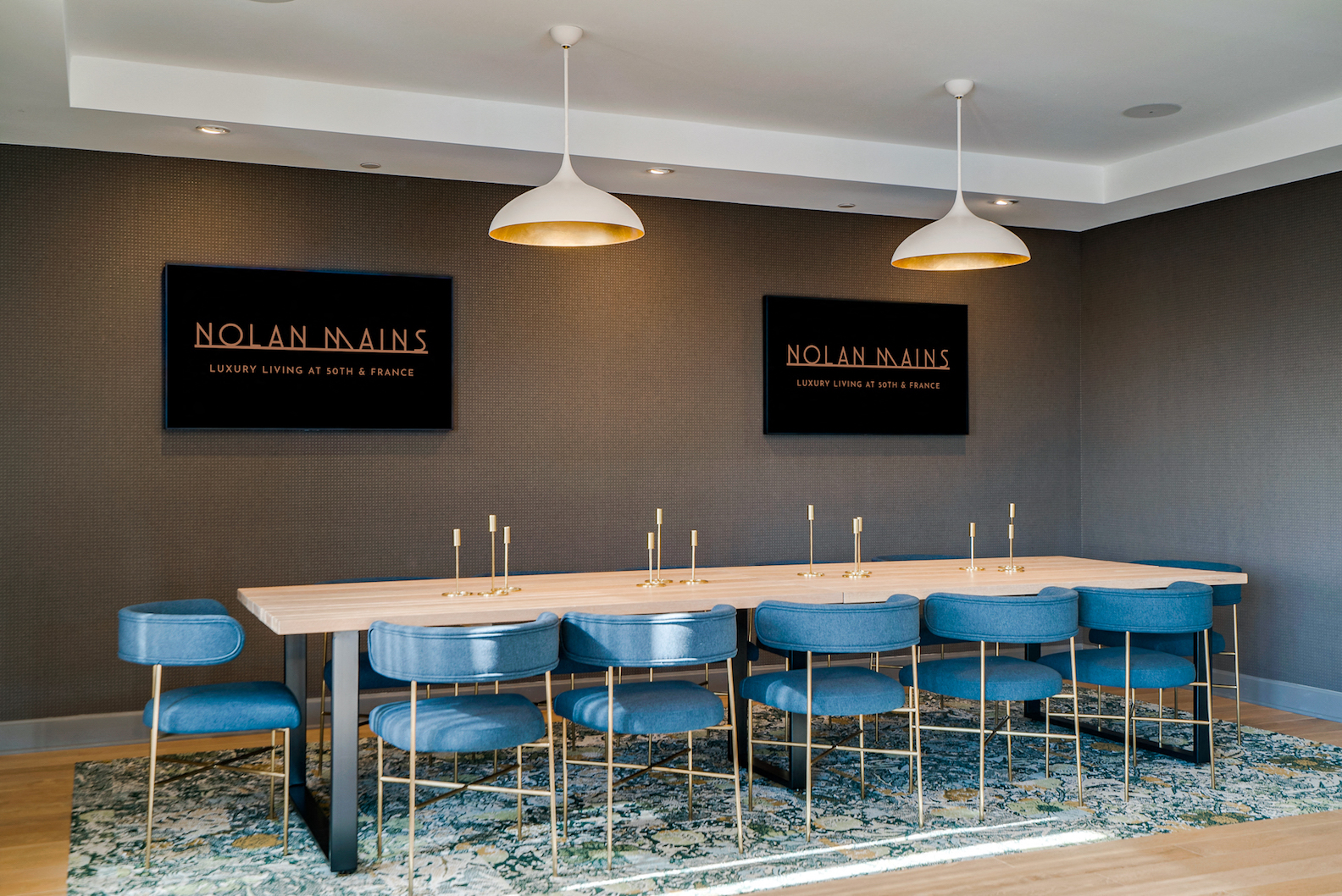 a long communal table with blue chairs in a conference room