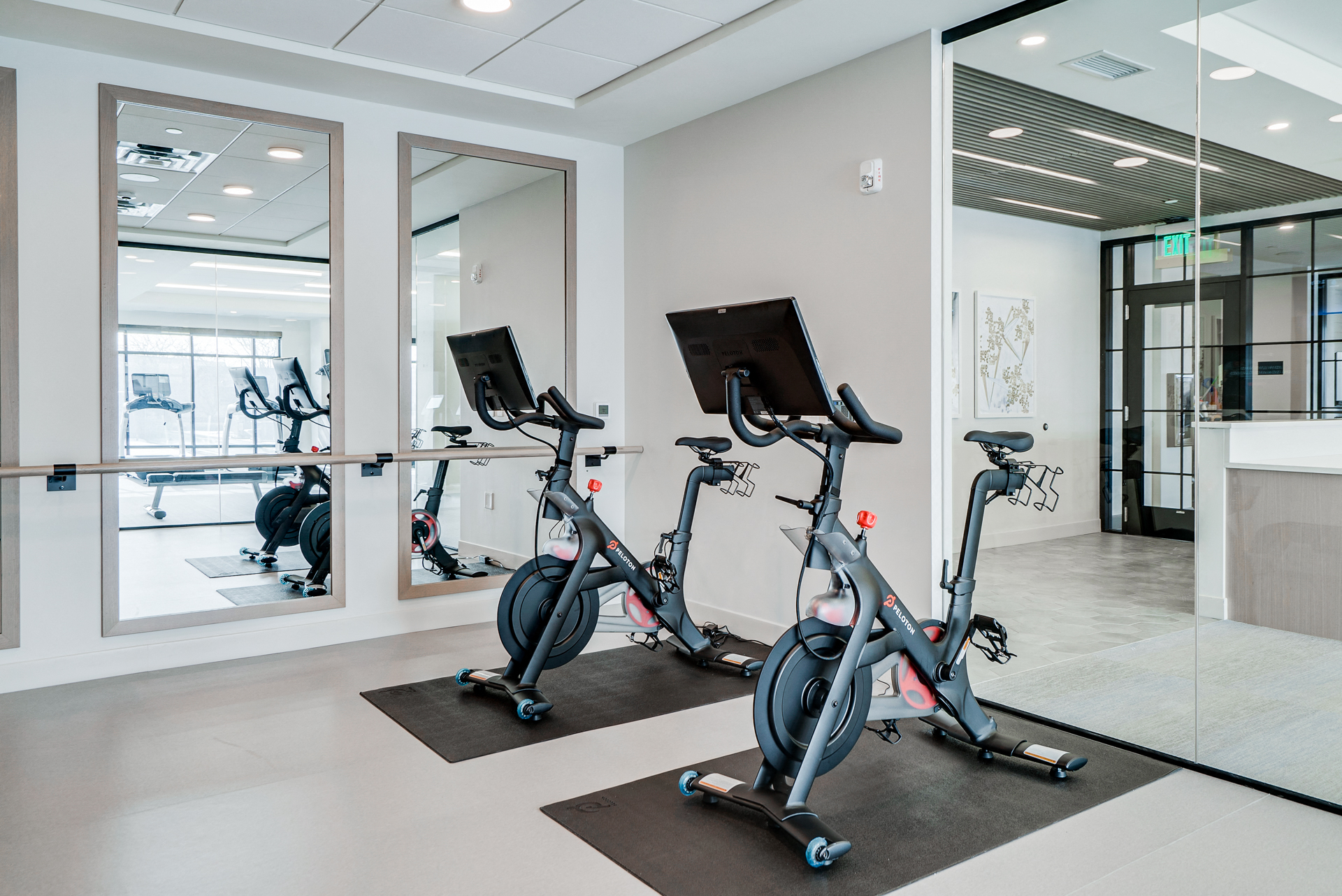 a gym with exercise bikes and mirrors in the wall