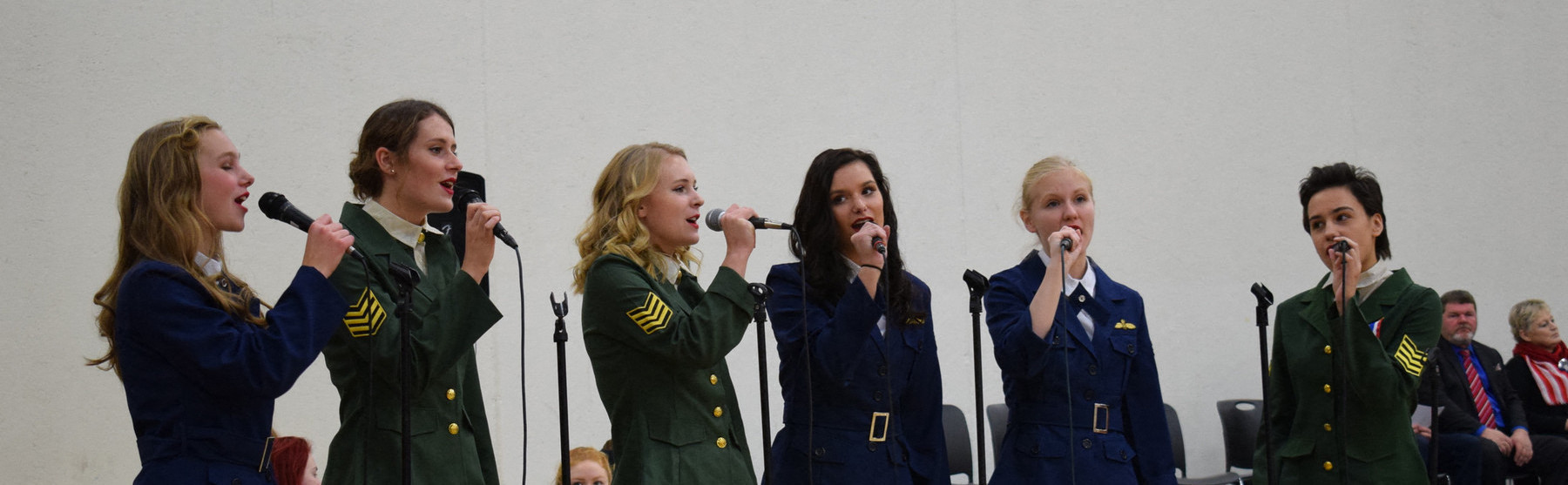 a group of people singing with microphones