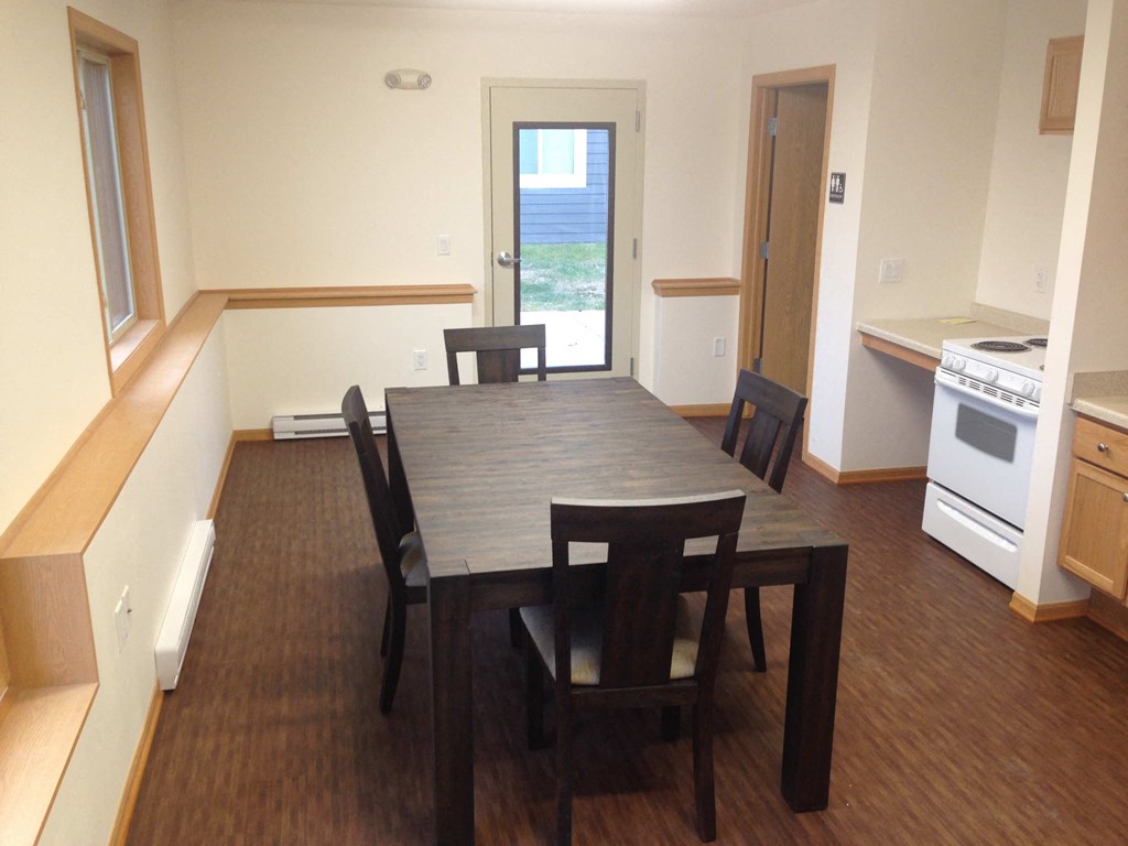 an empty kitchen and dining room with a table and chairs