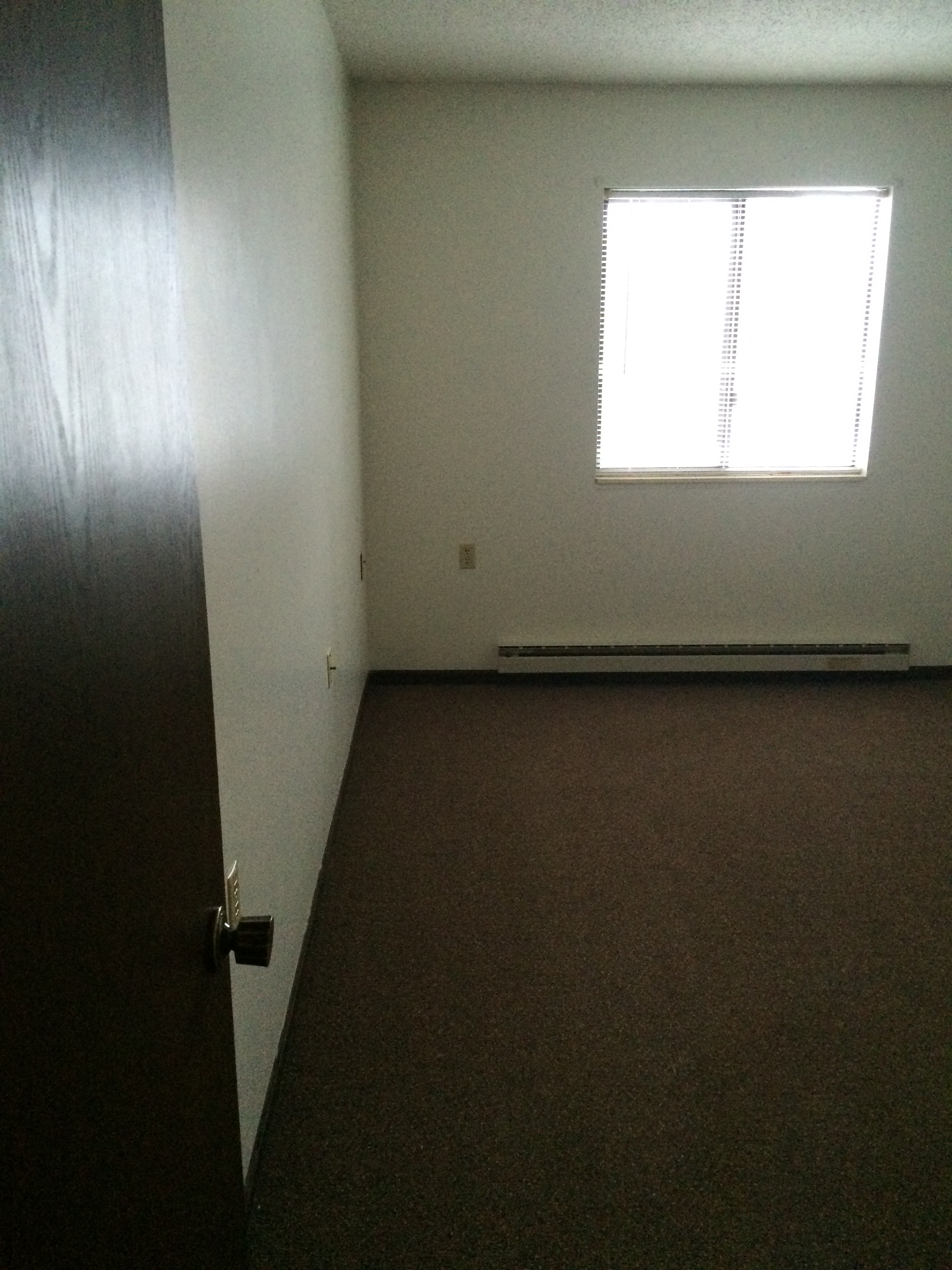 an empty room with a window and a door