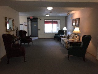A living room with a couch, chair, and lamp.