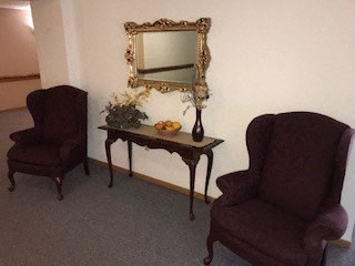 Two chairs and a table with flowers on it.